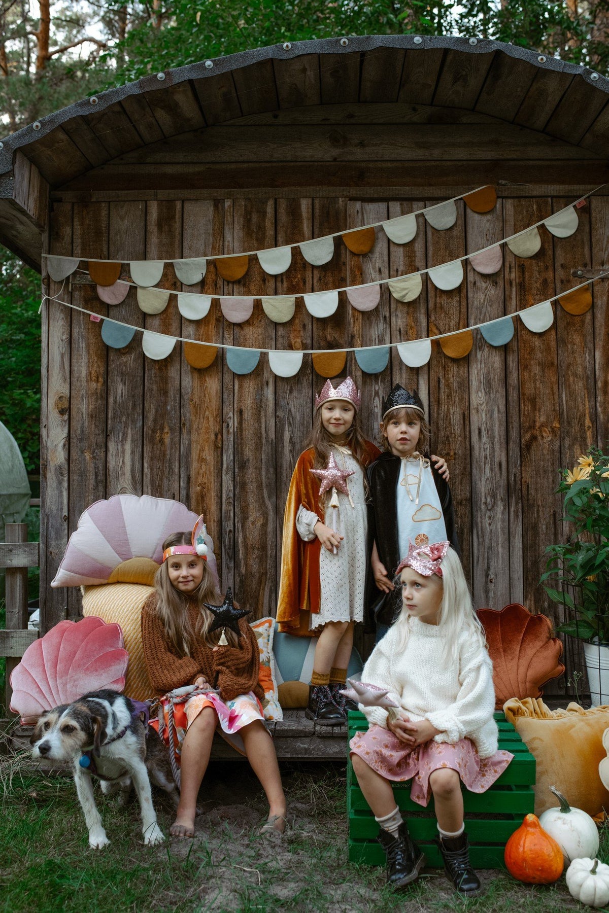 1. Four children in costume, one wearing gold sequin cat mask, posing with dog in front of wooden backdrop