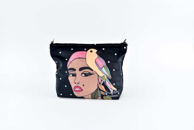 5. Garbanota black makeup bag with artistic print, shown with makeup brushes and cosmetics on wooden floor