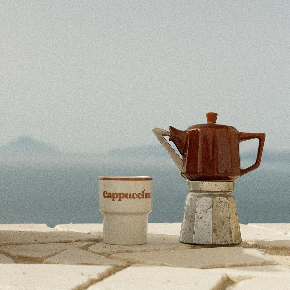 4. Terra Mamma ceramic cappuccino mug with moka pot on stone ledge with sea view
