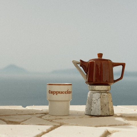 4. Terra Mamma ceramic cappuccino mug with moka pot on stone ledge with sea view