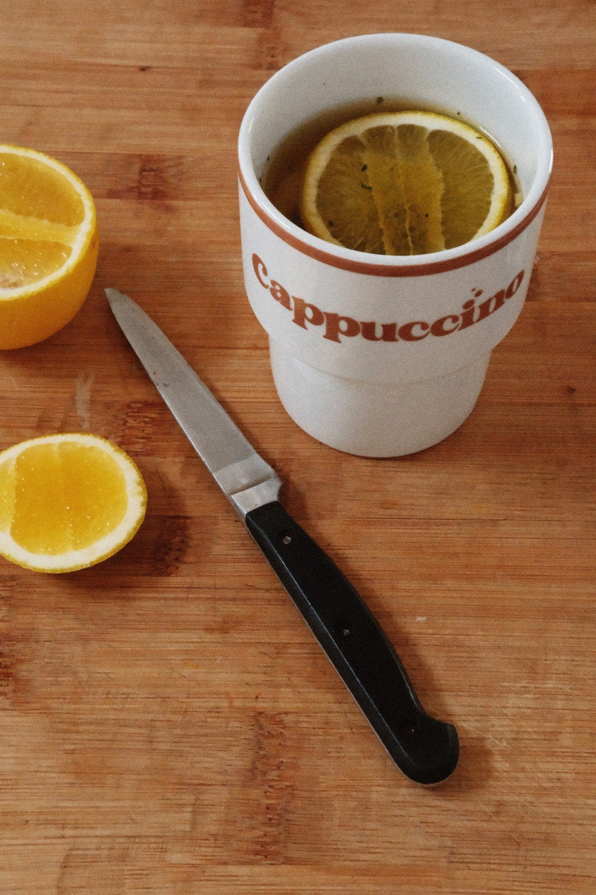 9. Terra Mamma ceramic cappuccino mug with lemon slices and knife on wooden surface