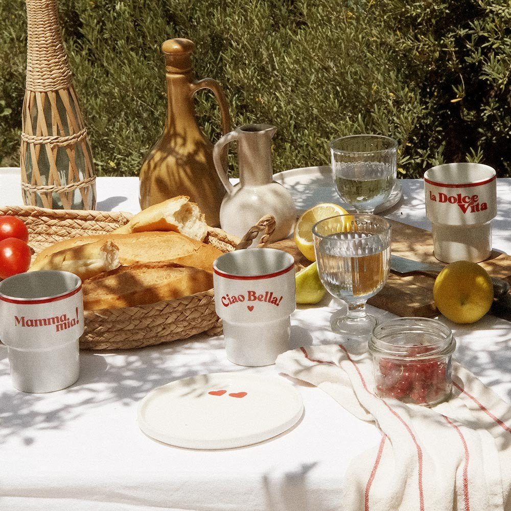 1. Terra Mamma 'Ciao Bella!' ceramic mug on outdoor table with 'Mamma Mia!' and 'La Dolce Vita' mugs, bread, and glassware
