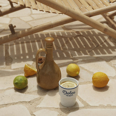 2. Terra Mamma ceramic mug with 'Dolce far Niente' text on stone floor with lemons and a jug
