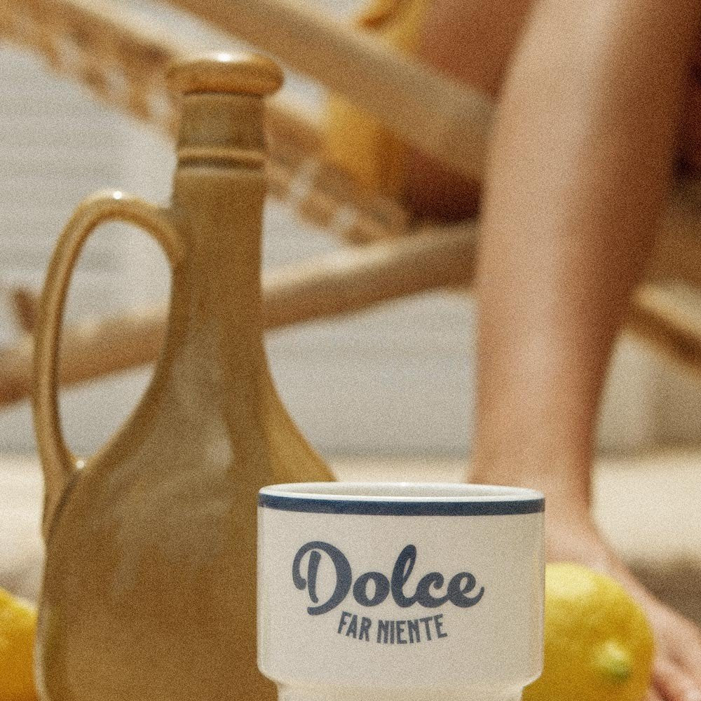 3. Close-up of Terra Mamma ceramic mug with 'Dolce far Niente' text next to a jug and lemons