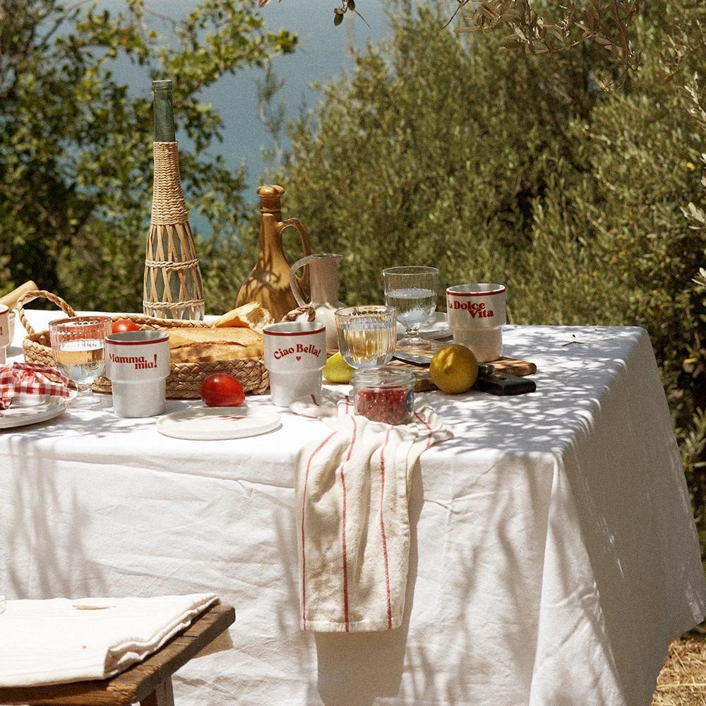 4. Terra Mamma 'La Dolce Vita' ceramic mug on outdoor dining table with various Italian-themed items