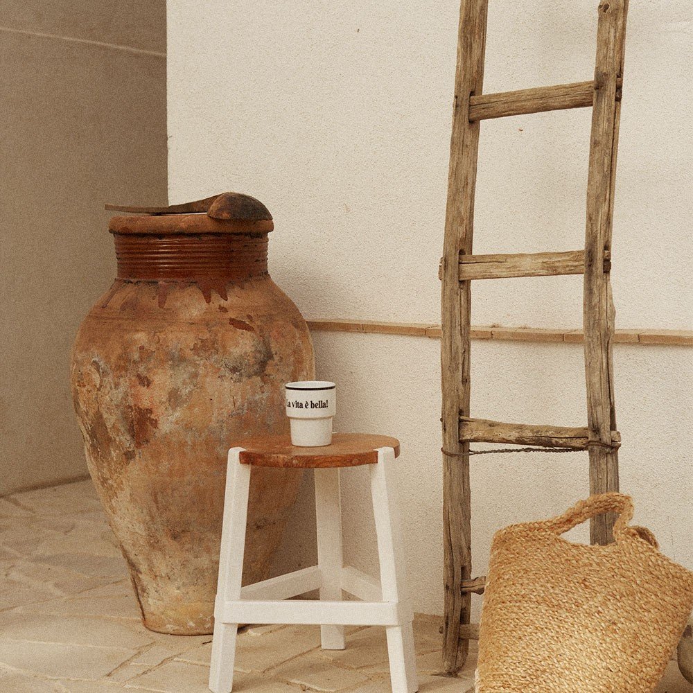 3. Terra Mamma ceramic mug with 'La vita è bella!' text on rustic stool beside clay pot and ladder