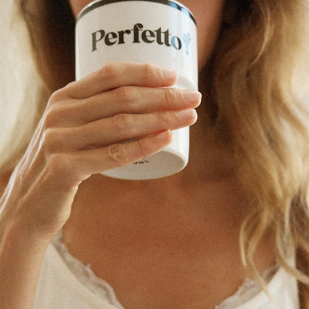 7. Close-up of woman drinking from Terra Mamma Perfetto ceramic mug with 'Perfetto!' text, wearing a white top