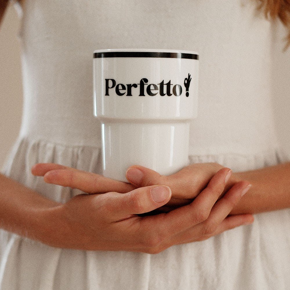 2. Woman holding Terra Mamma Perfetto ceramic mug with 'Perfetto!' text against her white dress