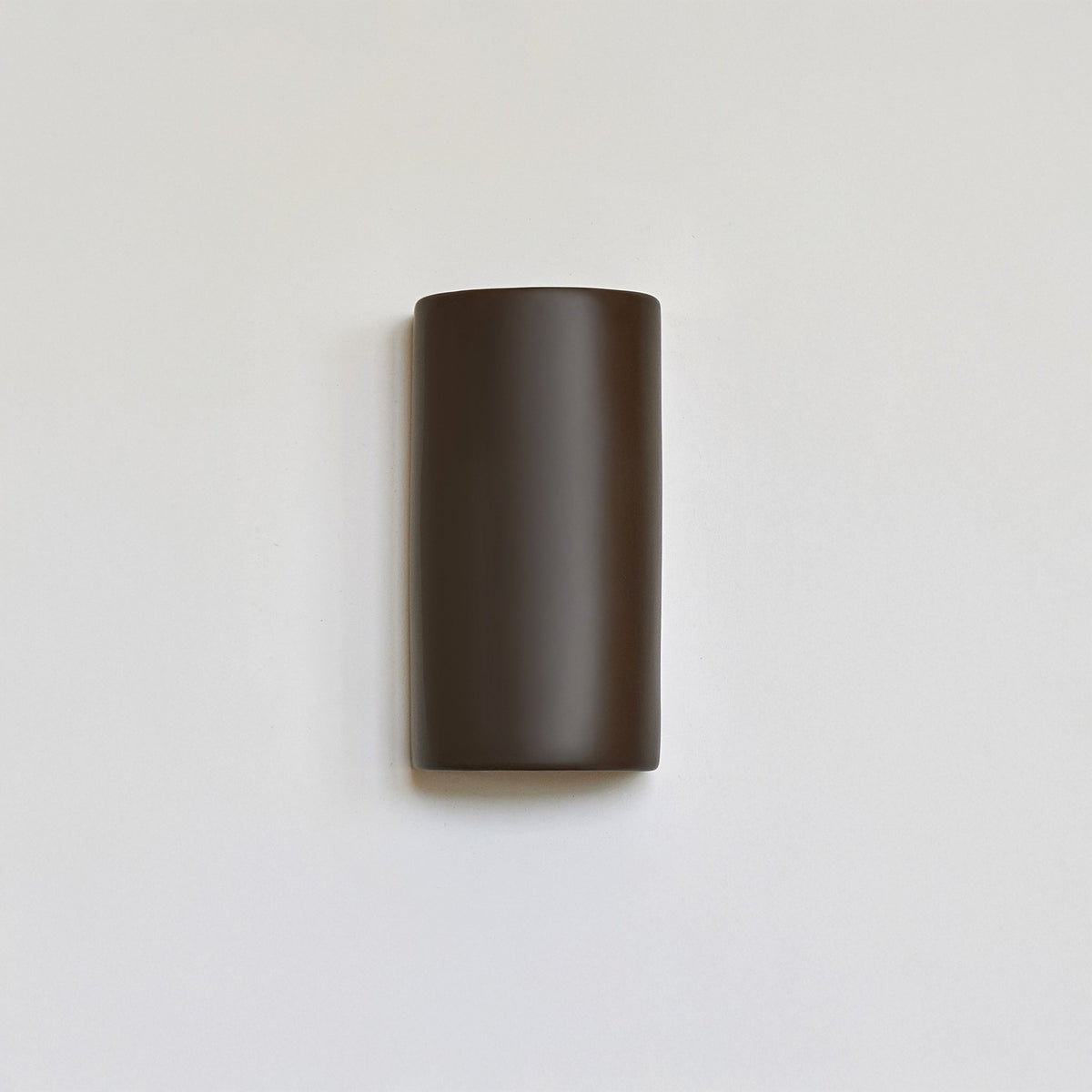 2. Brown ceramic wall light sconce by Ora on a white background