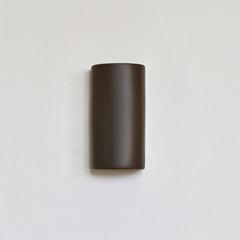 2. Brown ceramic wall light sconce by Ora on a white background