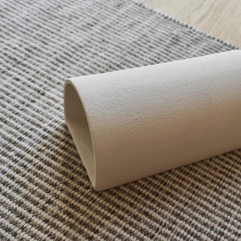 3. Detail shot of extra matte white textured ceramic wall light by Ora, showing the texture on a striped surface.