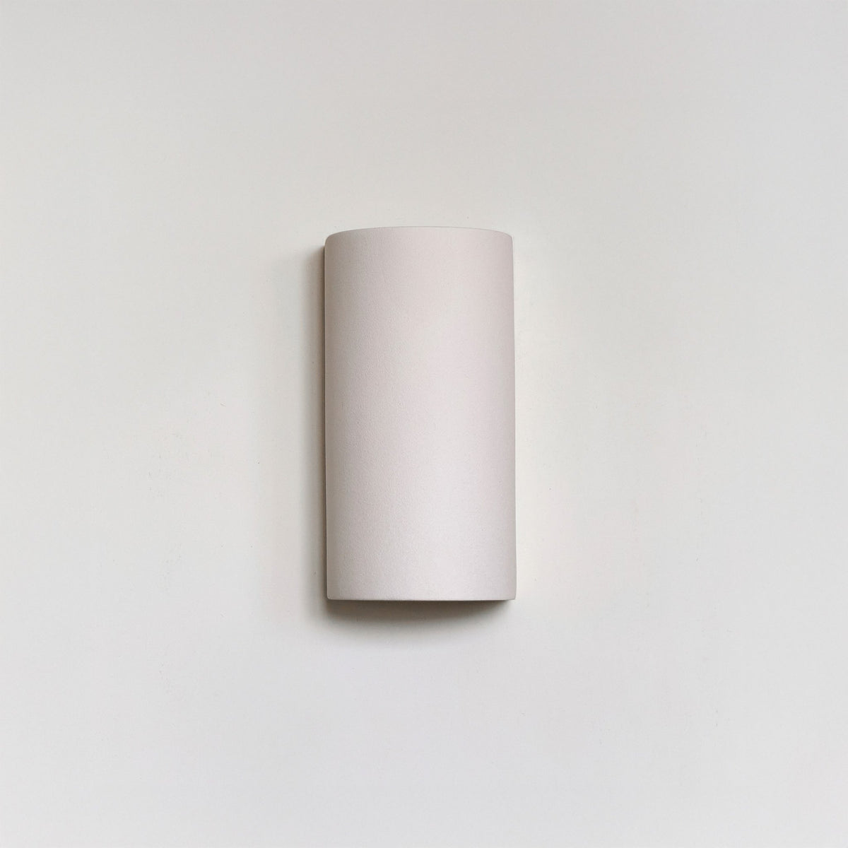 2. Studio shot of extra matte white textured ceramic wall light by Ora against a plain background.