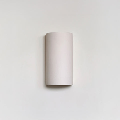 2. Studio shot of extra matte white textured ceramic wall light by Ora against a plain background.
