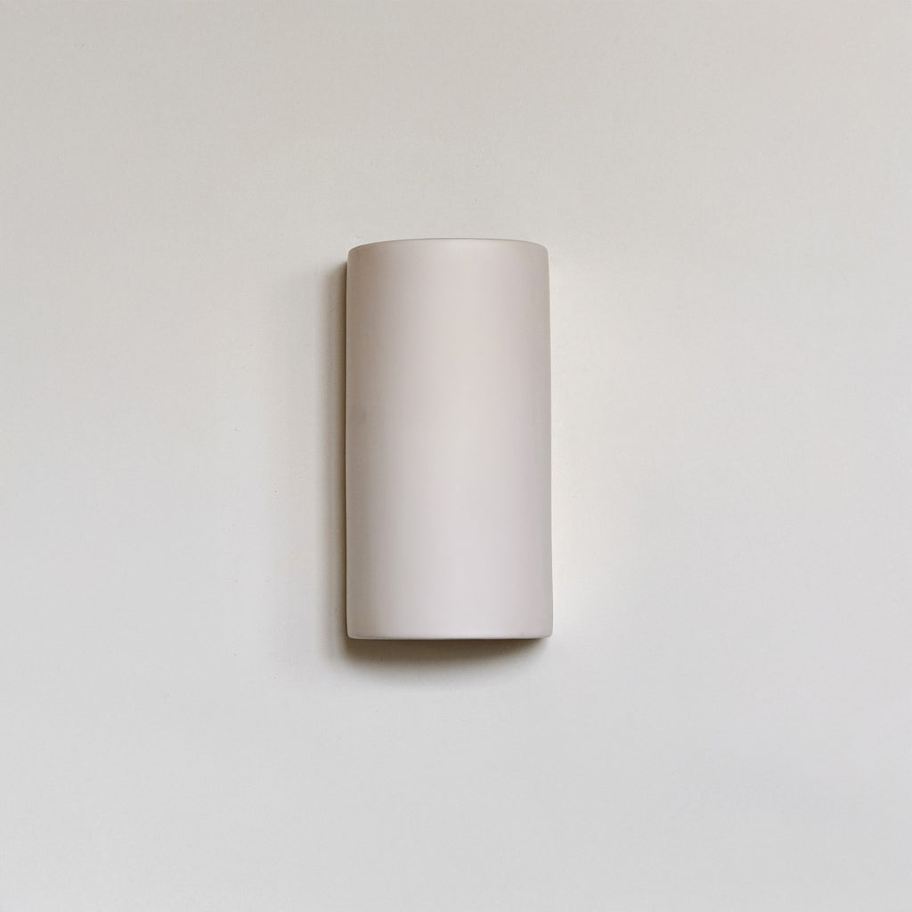 2. Off-white ceramic wall sconce by Ora on a plain background