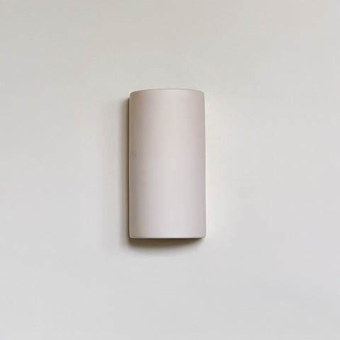 2. Off-white ceramic wall sconce by Ora on a plain background