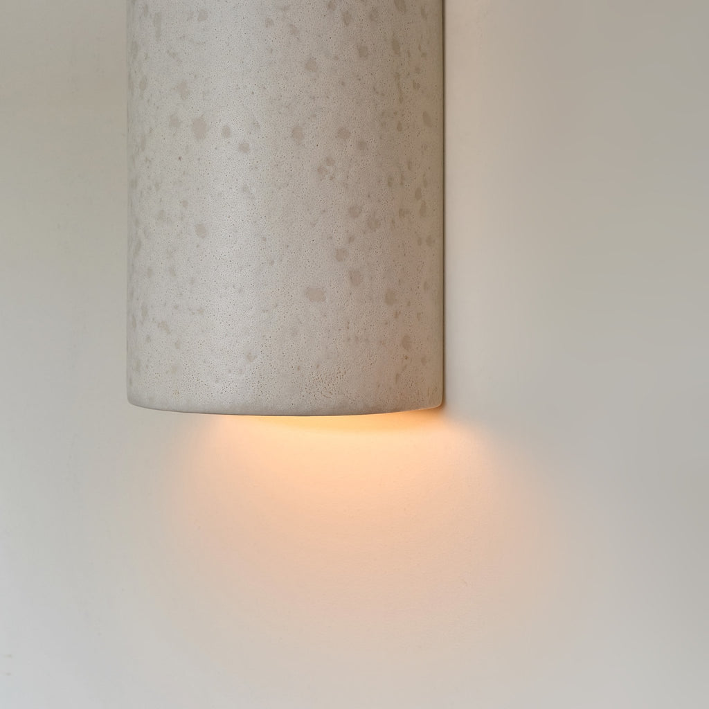 3. Close-up of ceramic wall light in raw white with warm light glow
