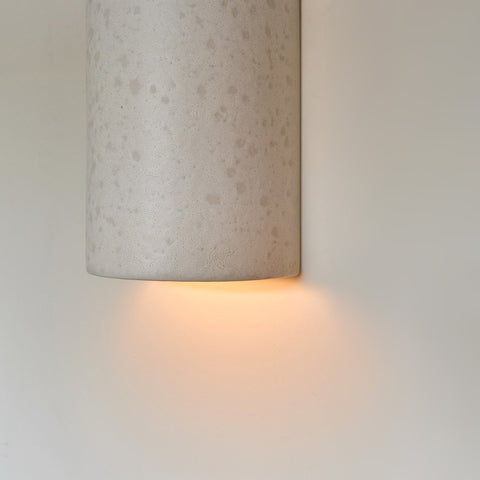 3. Close-up of ceramic wall light in raw white with warm light glow