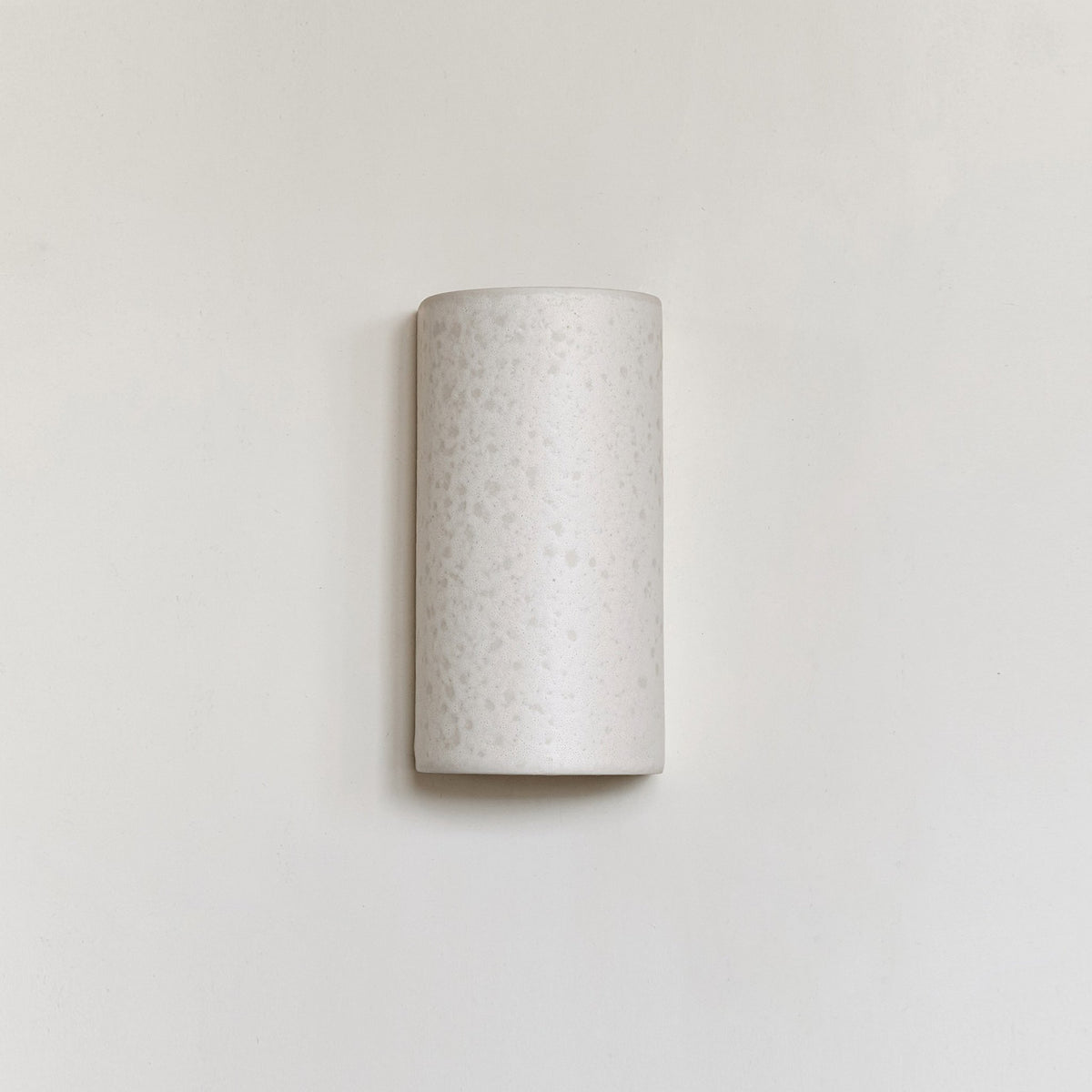 2. Studio shot of ceramic wall light in raw white on plain wall