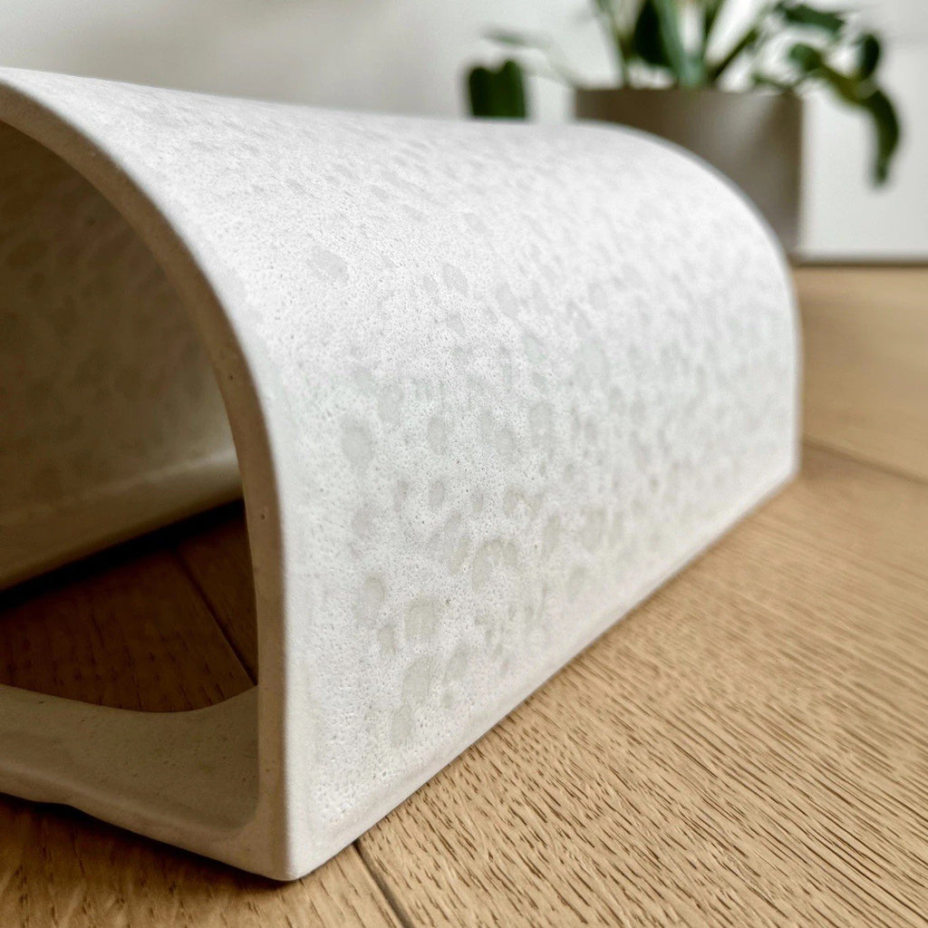 2. Close-up of raw white ceramic wall light showing texture and curve