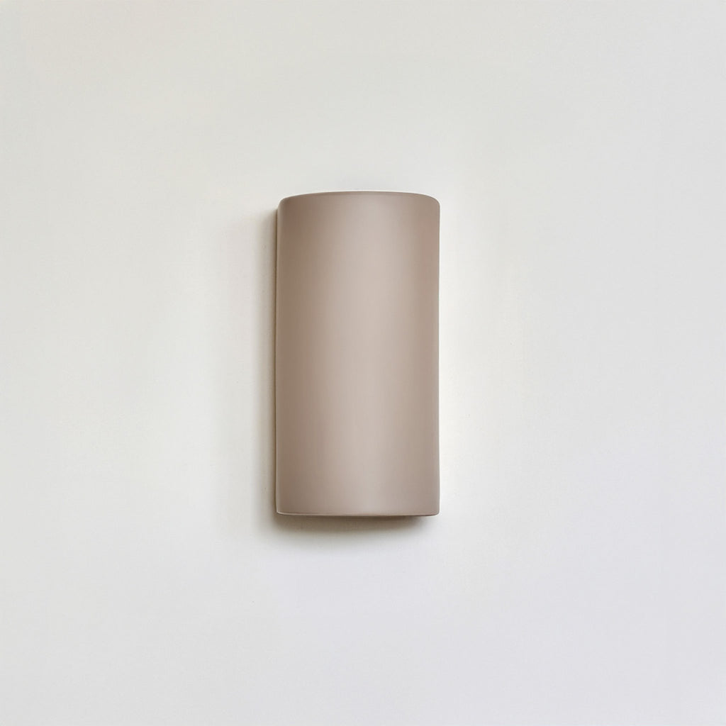 7. Studio shot of taupe ceramic wall light sconce on white background, highlighting its curved design