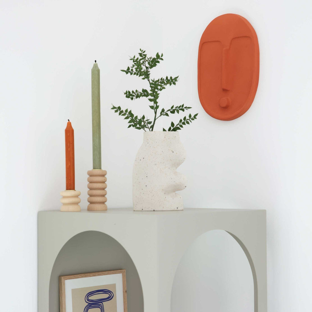 4. Terracotta orange ceramic wall mask by 5mm Paper on a wall with minimalist decor