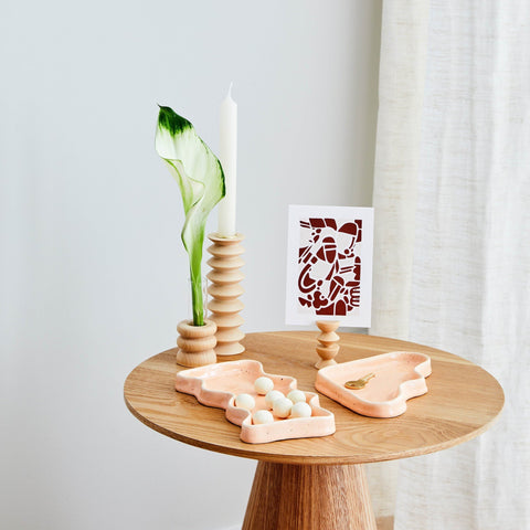 2. Ceramic Wave Tray in peach triangle design on wooden table with decor items, highlighting playful elegance
