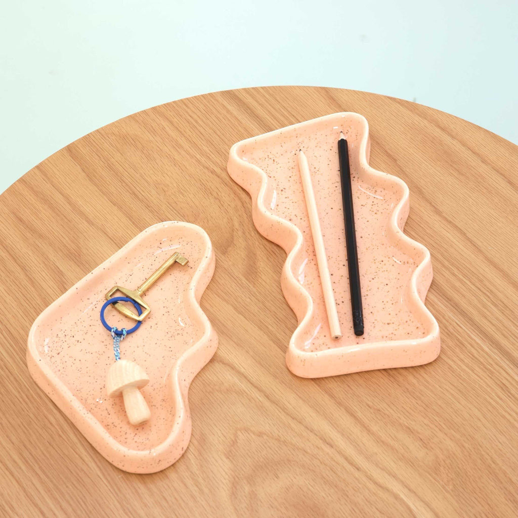 2. Close-up of Ceramic Wave Tray in speckled peach, used for organizing keys and chopsticks on a wooden surface