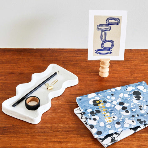 2. Ceramic Wave Tray in speckled white on a desk with stationery and notebooks