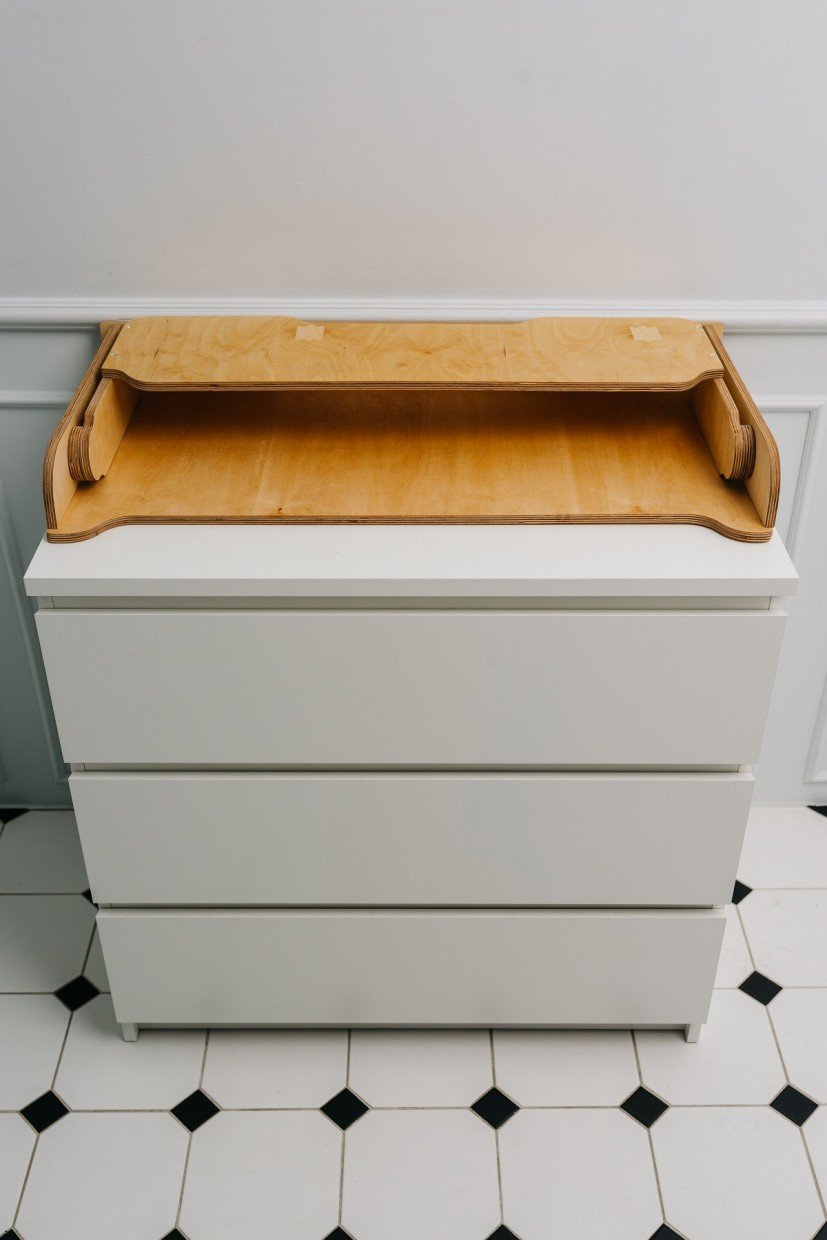 4. Birch plywood changing table top on white chest of drawers in a tiled room
