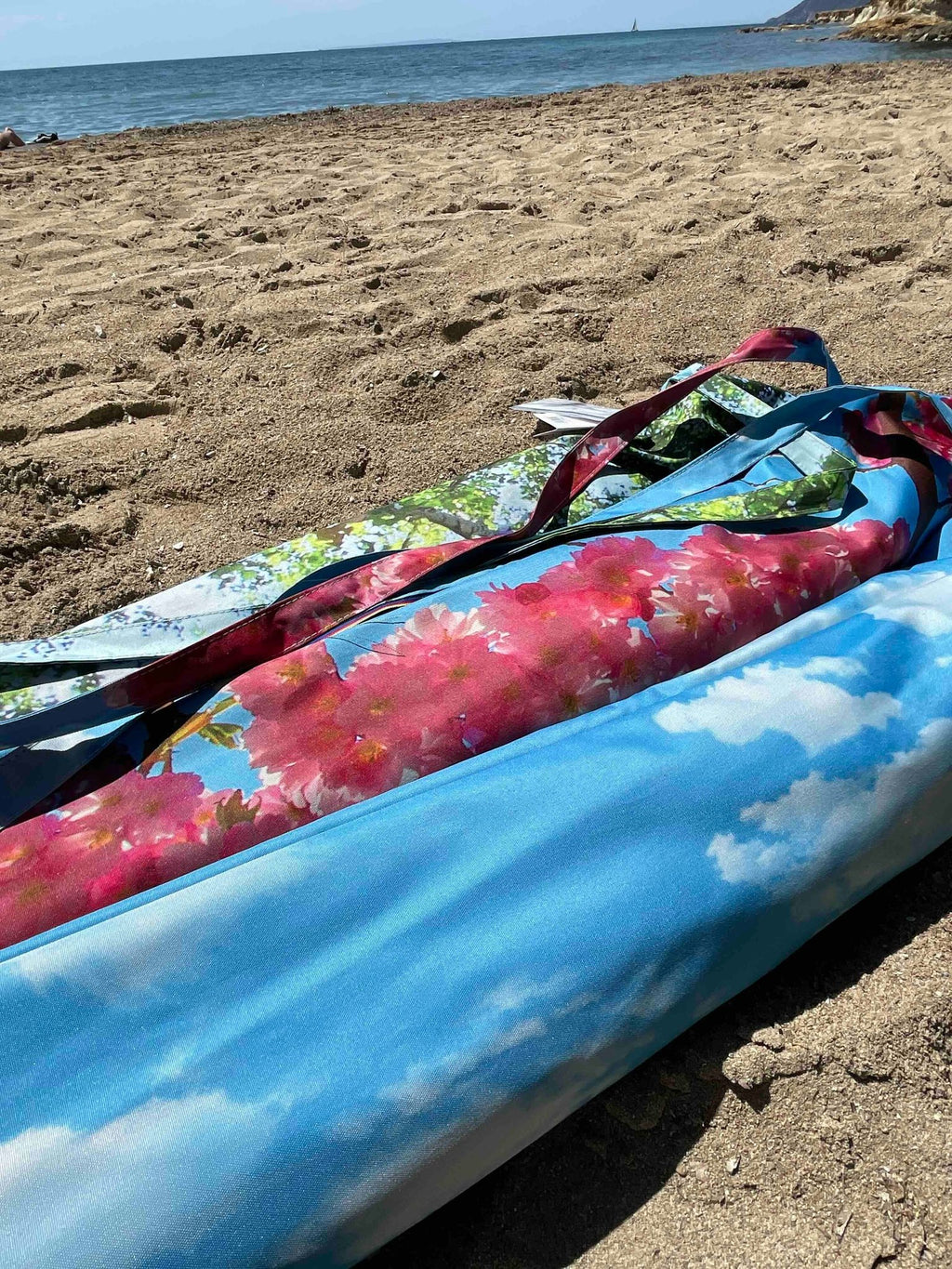 4. Flat lay of cherry beach and terrace parasol with floral and sky prints on sandy beach