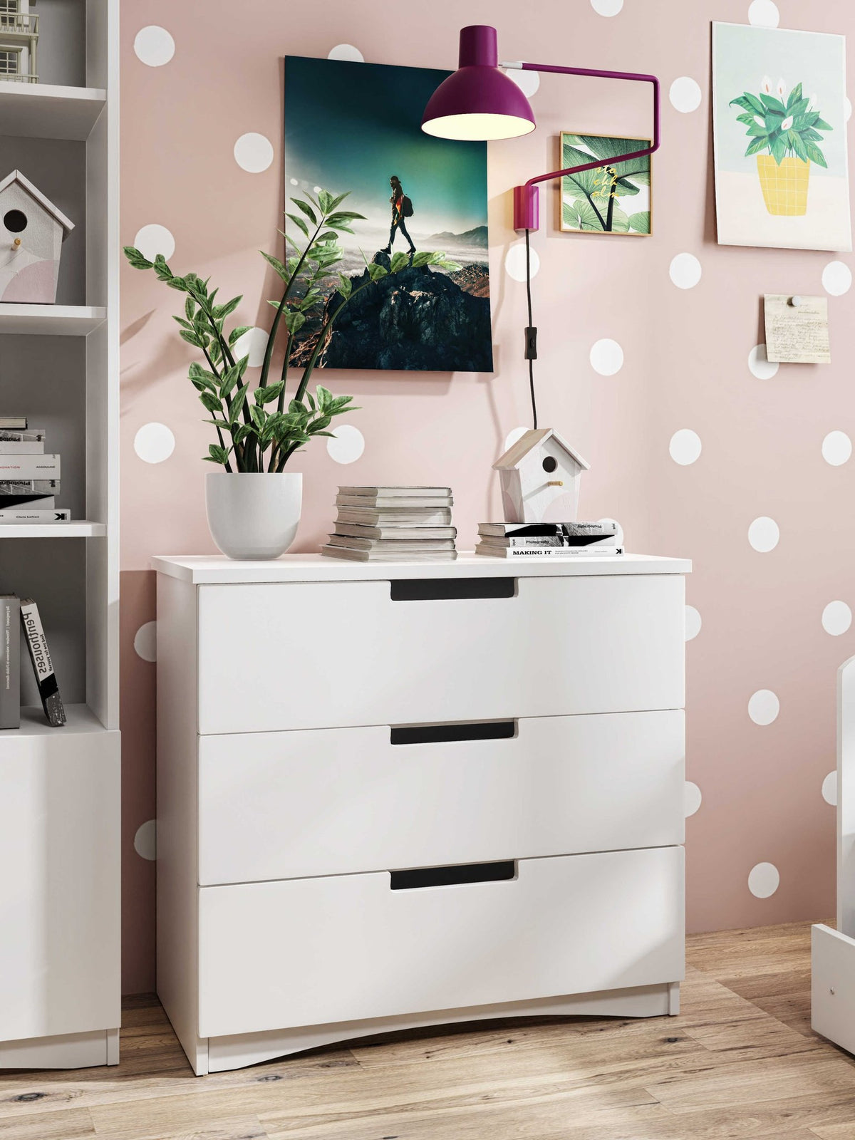 1. White chest of drawers in a child's room with polka dot wall, plant, and books on top