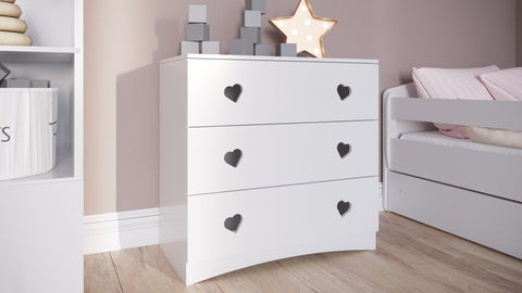 1. White chest of drawers with heart-shaped handles next to a child's bed in a cozy room
