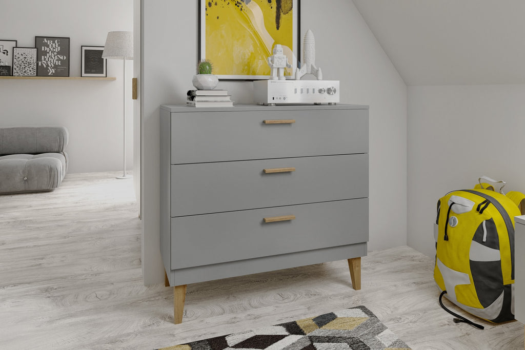 4. Kocot Kids Kubi grey chest of drawers in a modern room setting with decorative items on top