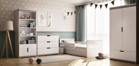 1. Children's room with white chest of drawers, bed, and wardrobe, featuring heart-patterned wallpaper and natural light from a window