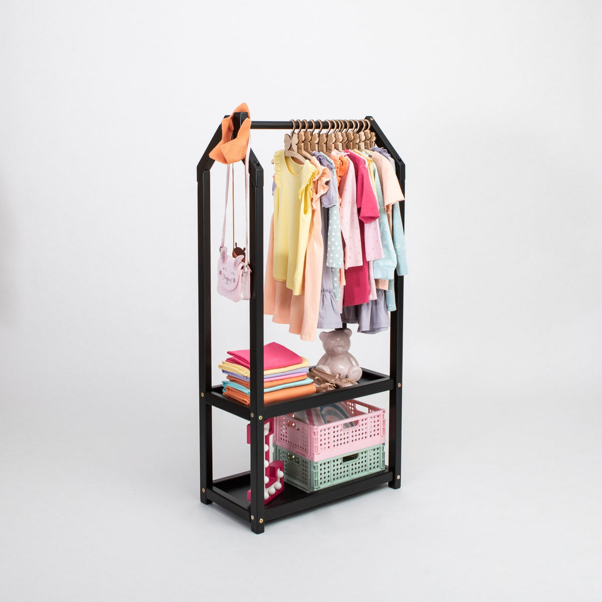 1. Black house-shaped clothing rack with colorful children's clothes and storage baskets on a white background