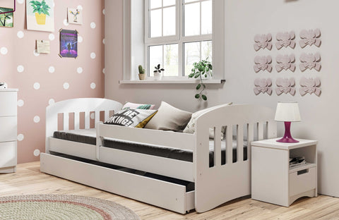 3. White children's bed with guardrail in playful room with polka dot walls and colorful decor