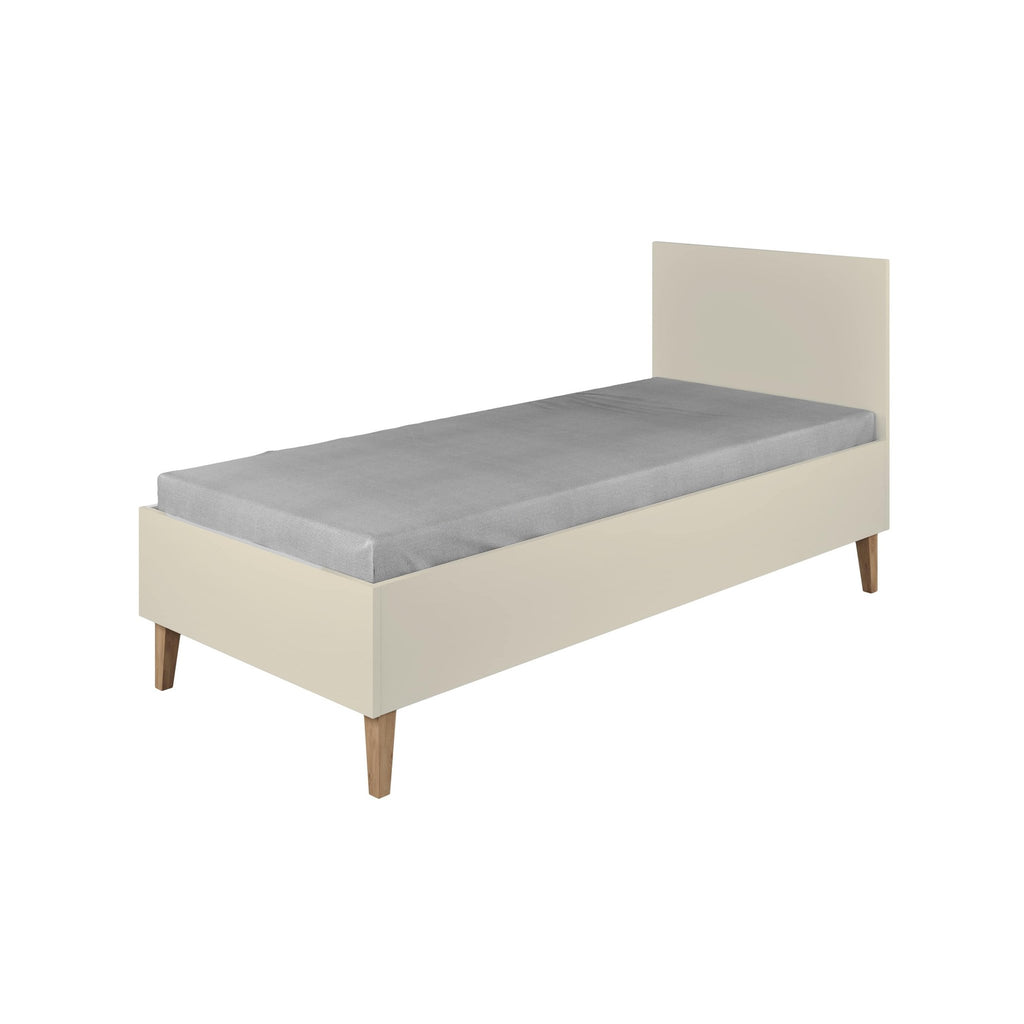 2. Children's bed Kubi in cashmere color with solid oak legs shown in a studio setting