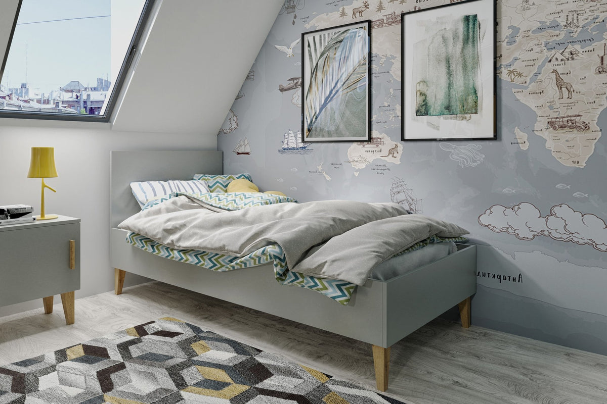 1. Grey Kubi bed in a child's room with world map wallpaper and geometric rug, creating a playful atmosphere