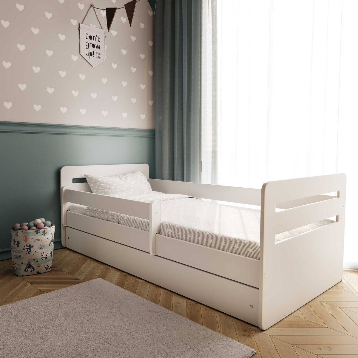 5. White children's bed with patterned bedding in a cozy room with heart wallpaper