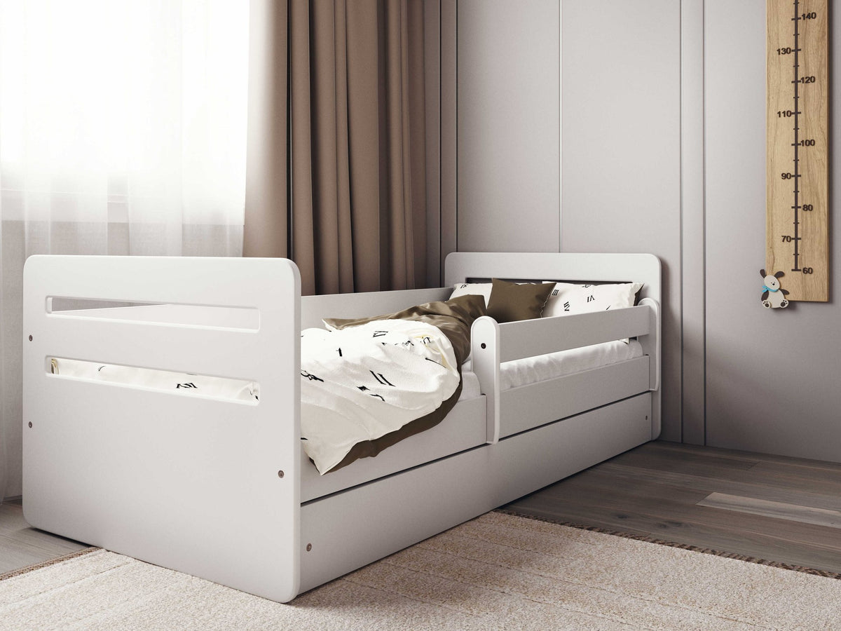 7. White children's bed with brown bedding in a softly lit room with growth chart
