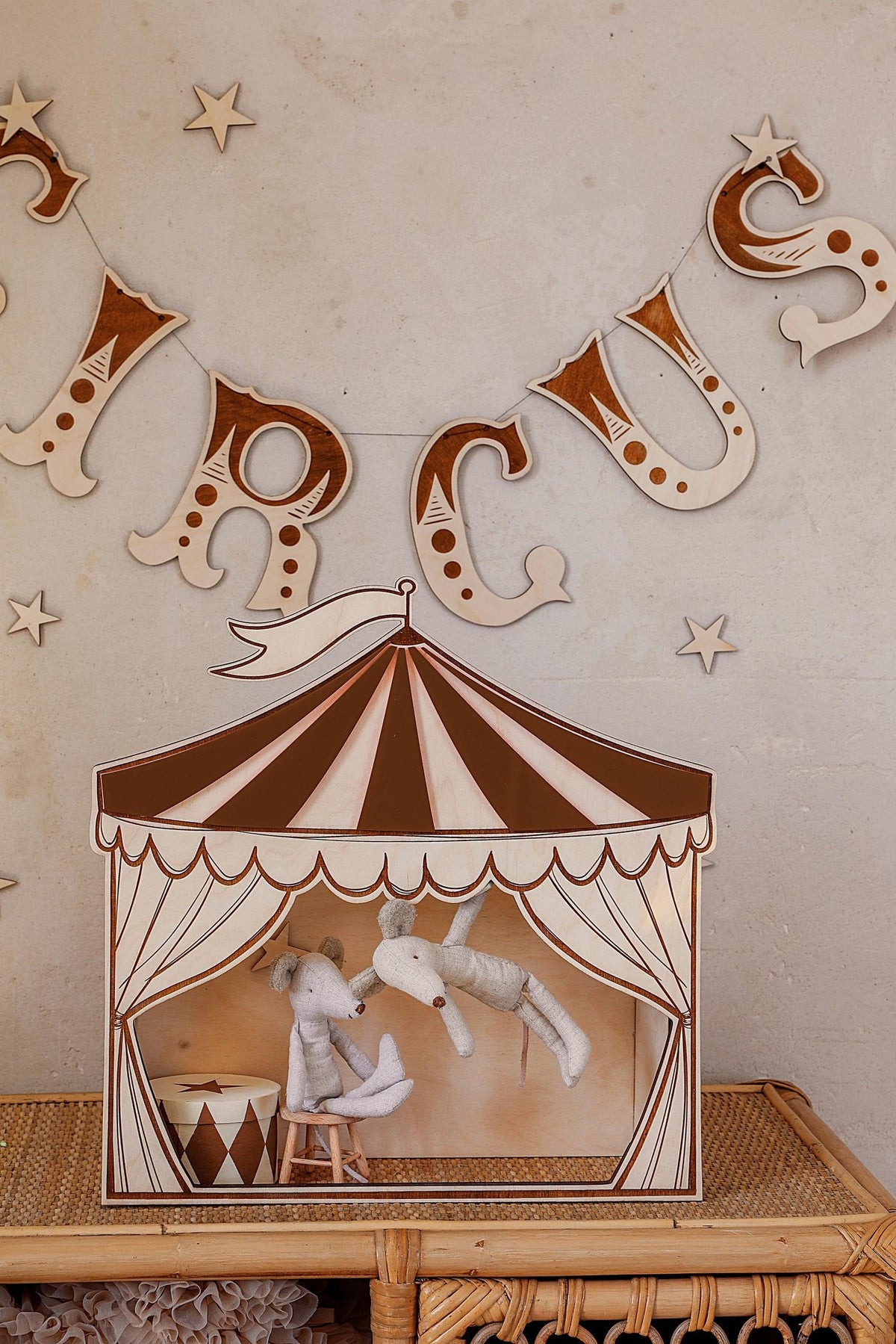 7. Brown and white circus puppet theater wall decoration with plush toys, set against a wall with circus-themed decor