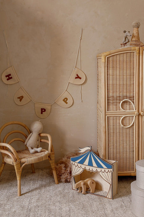 4. Cozy children's room with blue and white circus puppet theater on floor, surrounded by wicker furniture and playful decor