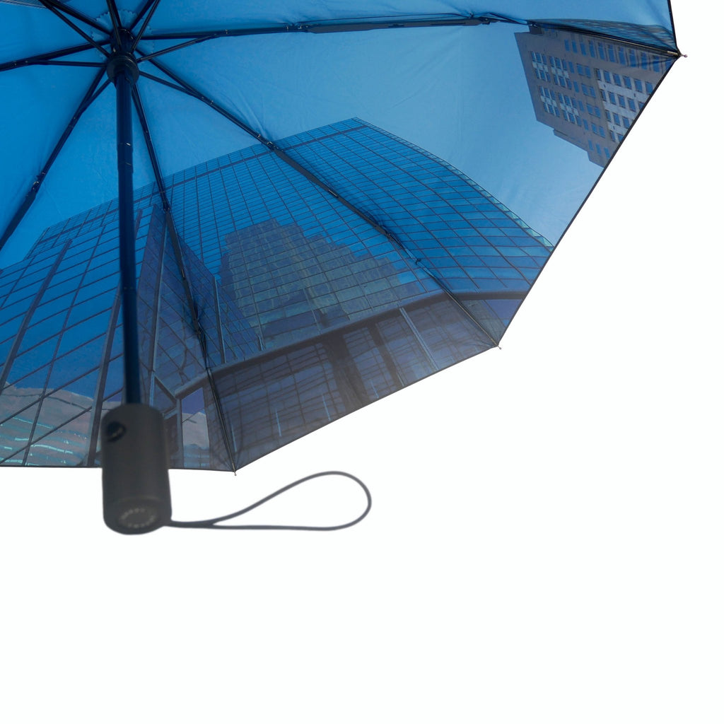 4. Close-up of city umbrella's blue cityscape pattern with black handle, emphasizing urban elegance