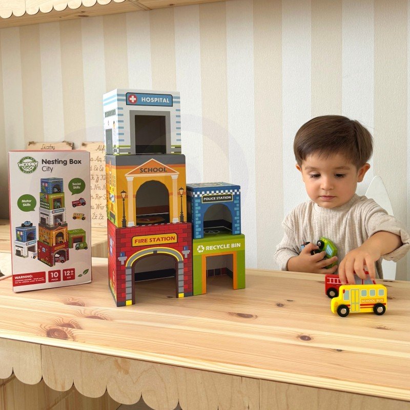 10. Young boy playing with colorful city-themed puzzle cubes and a school bus toy on a wooden table
