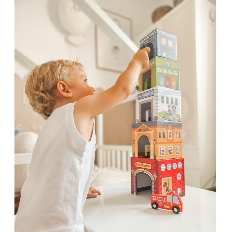 9. Child reaching for colorful city-themed puzzle cubes stacked in a tower