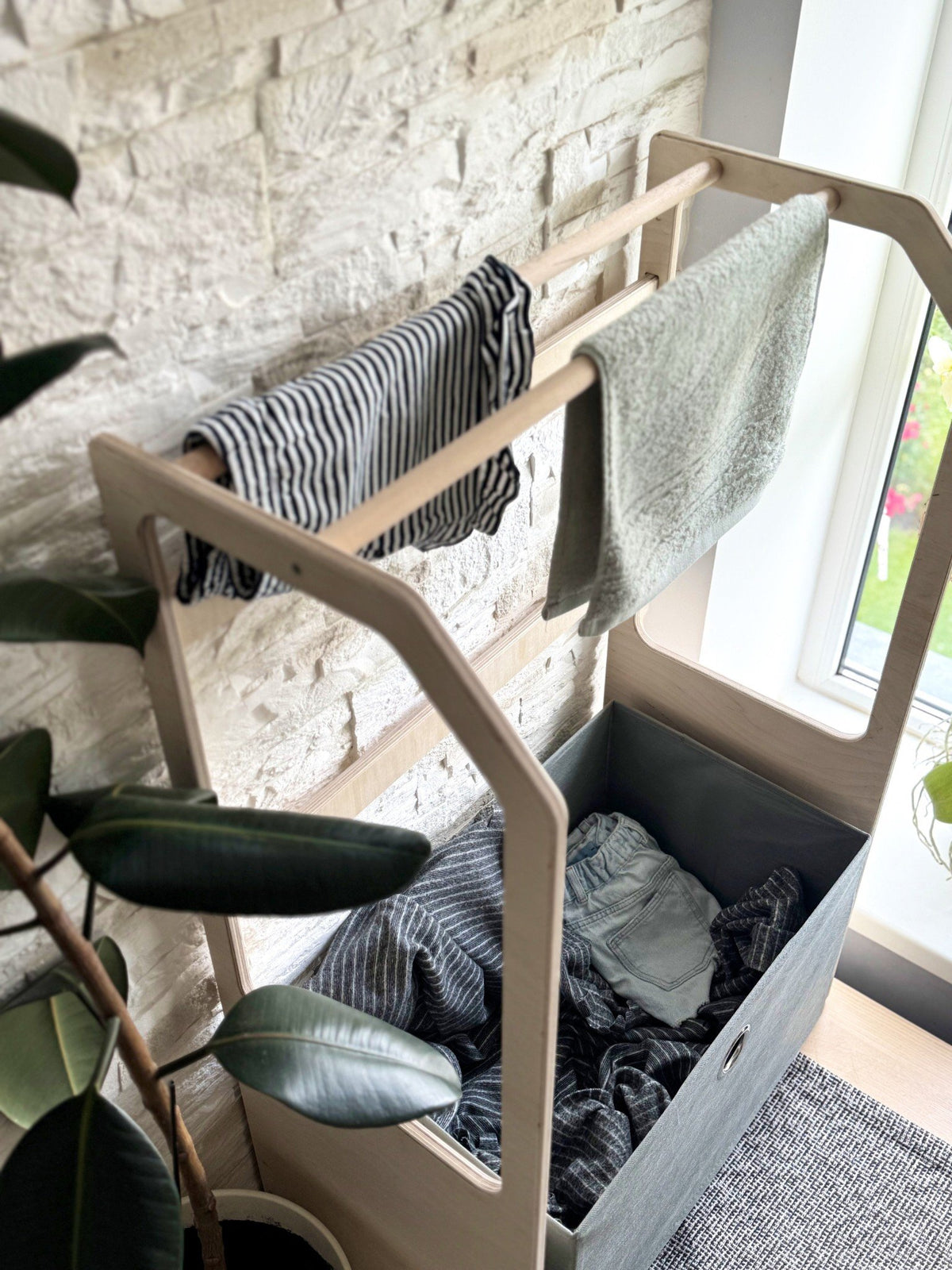5. Top view of wooden clothes drying rack with striped and grey towels, grey fabric basket