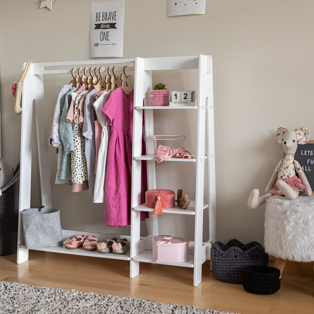 12. White clothing rack with pink and blue toddler clothes in a cozy nursery setting