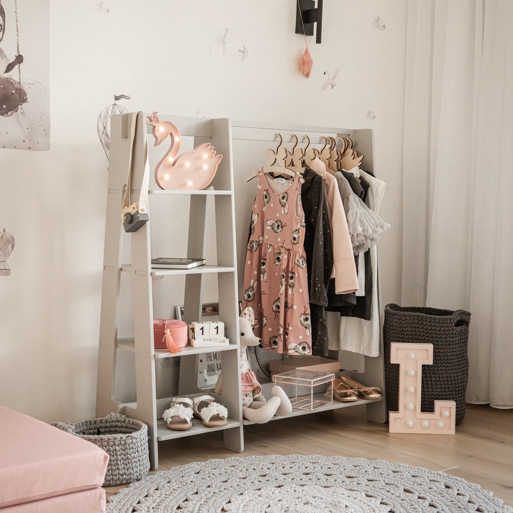 15. Grey clothing rack with toddler clothes and toys in a stylish children's room