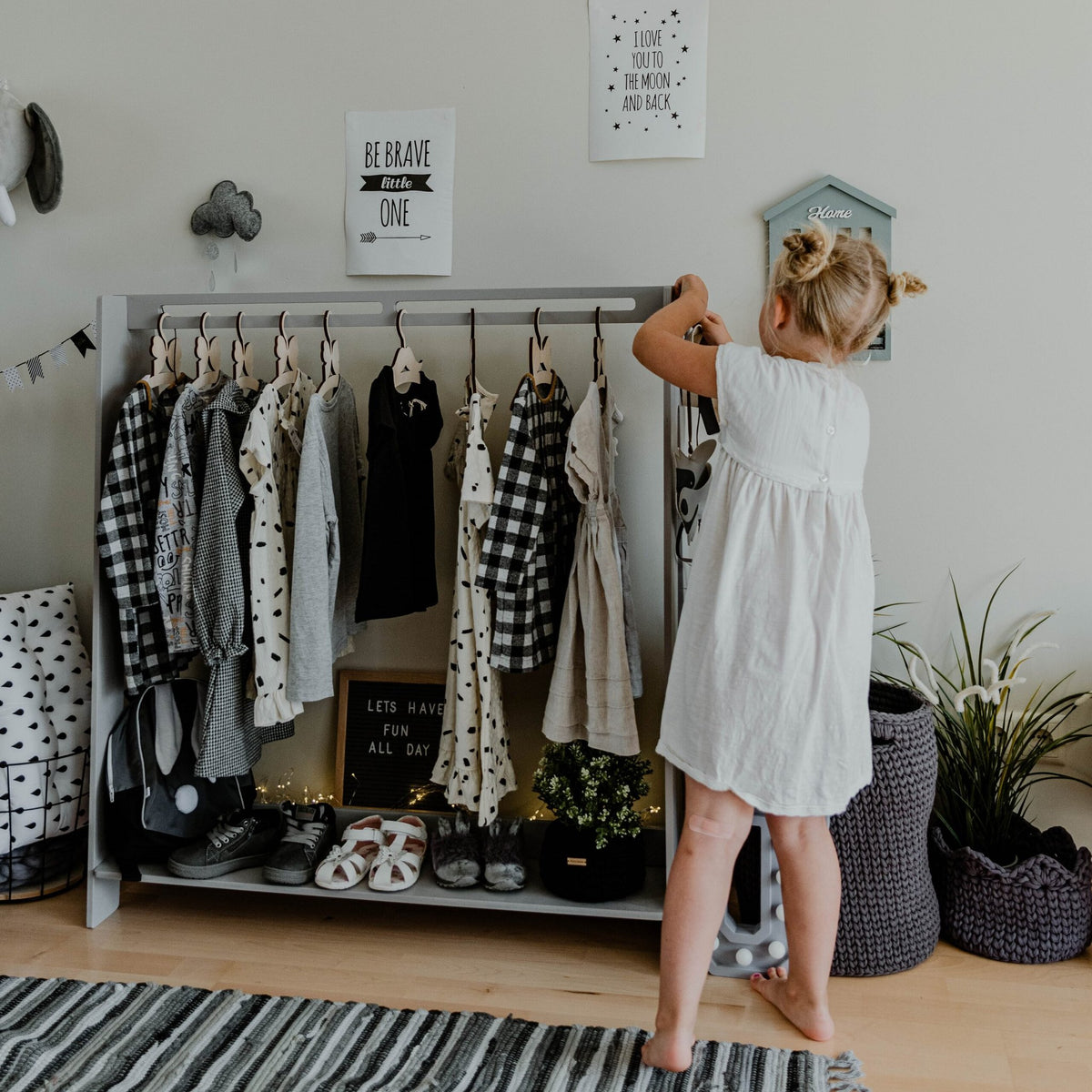 11. Grey toddler clothing rack with monochrome children's clothes in a stylish room