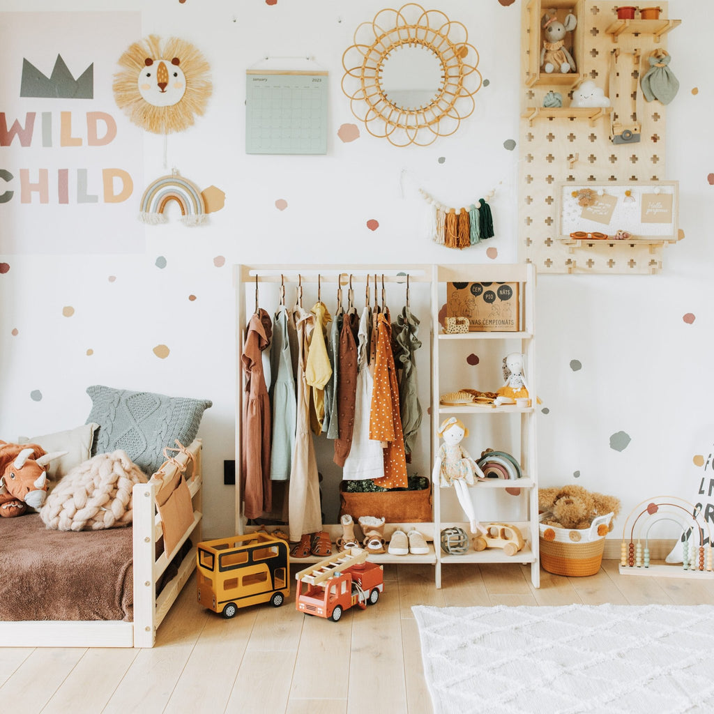 1. Children's room with wooden clothing rack holding colorful toddler clothes and toys, enhancing nursery decor